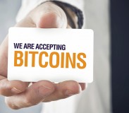 Businessman holding card with title WE ARE ACCEPTING BITCOINS